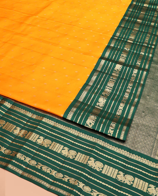 Orange Vasundhara Silk Saree Elegantly Woven with Zari Buttas, Complemented by a Contrast Varisai Pettu Border of  Salngai, Neli, Mayil, and Kodi Visiry Designs, Zari-Rich Jaal Pallu, and Paired with a Contrast Zari-Bordered Blouse