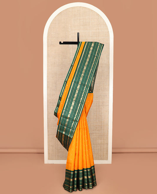 Orange Vasundhara Silk Saree Elegantly Woven with Zari Buttas, Complemented by a Contrast Varisai Pettu Border of  Salngai, Neli, Mayil, and Kodi Visiry Designs, Zari-Rich Jaal Pallu, and Paired with a Contrast Zari-Bordered Blouse