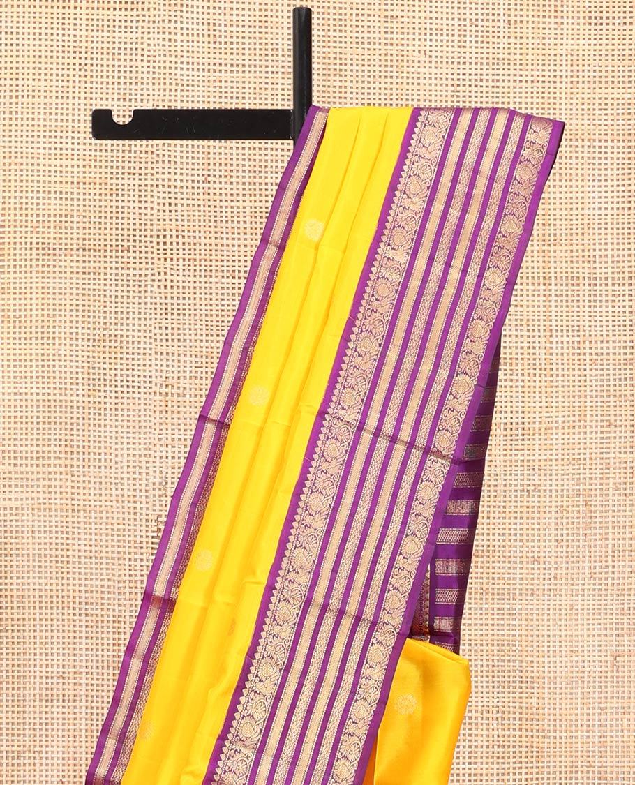 Yellow Vasundhara Silk Saree, Sparsely Woven with Zari Buttas All Over Its Body, Complemented by a Contrast Border of Thilakam, Muthu, Mayil, and Mayil Kann Designs, Pallu of Zari Designs, and Paired with a Contrast Blouse