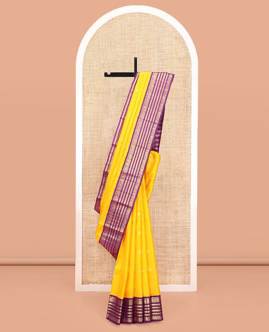 Yellow Vasundhara Silk Saree, Sparsely Woven with Zari Buttas All Over Its Body, Complemented by a Contrast Border of Thilakam, Muthu, Mayil, and Mayil Kann Designs, Pallu of Zari Designs, and Paired with a Contrast Blouse