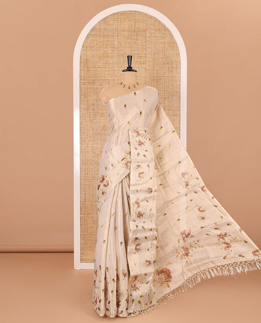 Cream leaf and floral printed tissue saree with border and pallu of floral and leaf print, a small floral printed blouse