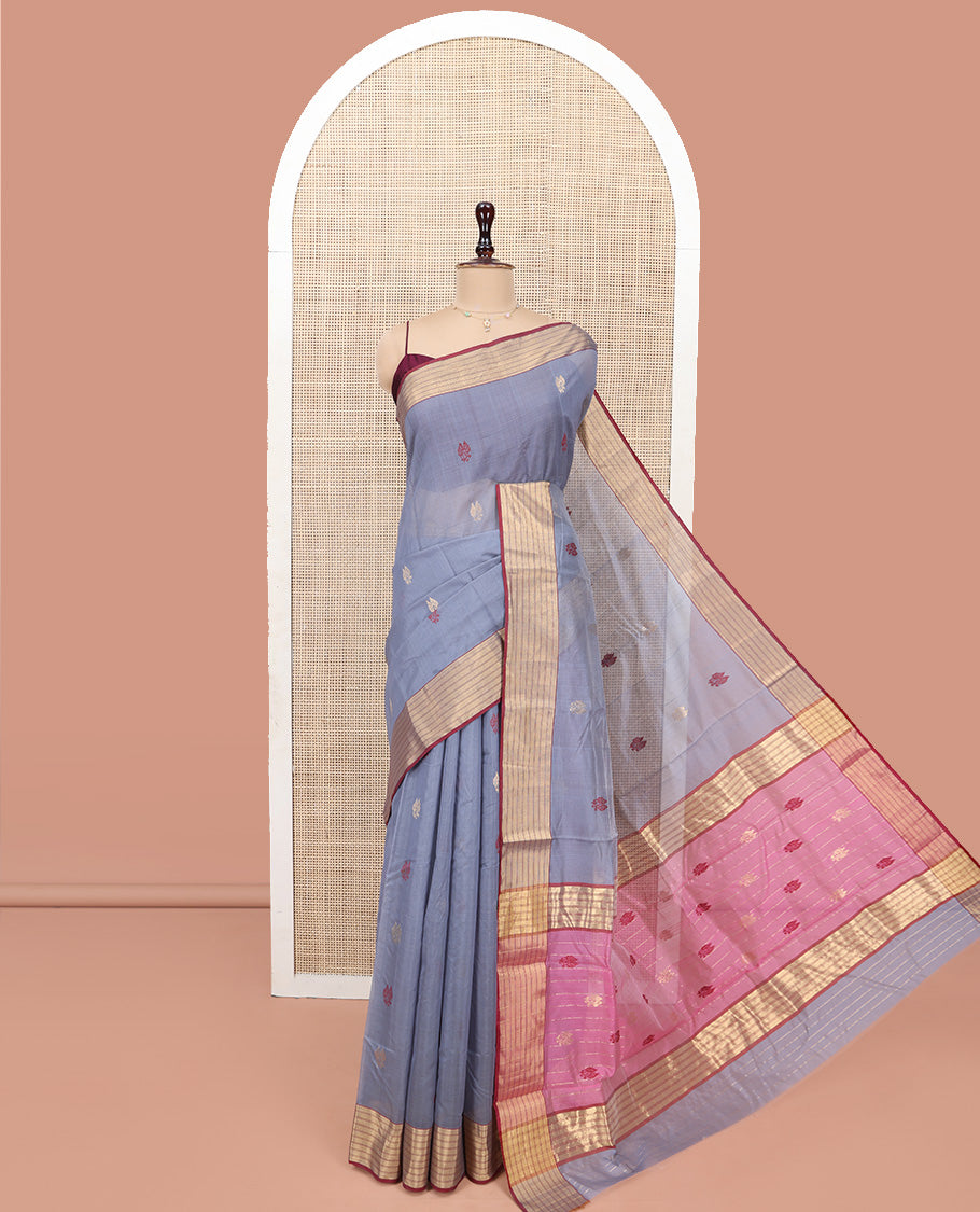 Grey Chanderi Cotton Saree, Delicately Woven with Leaf Buttas All Over Its Body, Complemented by a Contrast Zari Striped Border, Complemented by Contrast Pallu of Leaf Designs, and Paired with a Contrast Blouse