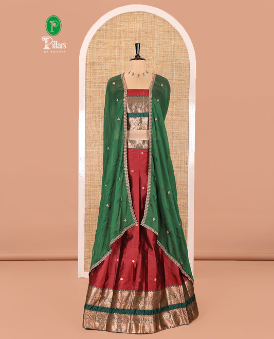 Maroon and Green Semi-Banarasi Half-Saree Featuring Zari Buttas Skirt, Complemented by Contrast Rettai Pettu, Traditional Border of Floral Creeper Designs, Paired with a Matching Blouse, and a Satin Georgette Embroidered Scallop Dhavani