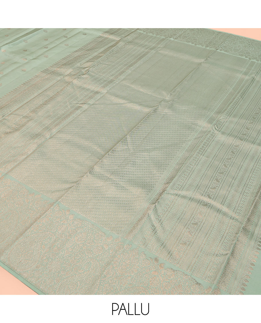 Green Kanchipuram Silk Saree, Delicately Woven with Zari Buttas All Over Its Body, Highlighted by a Zari Border of Floral and Paisley Designs, Grand Chevron Striped Pallu, and Paired with a Matching Blouse