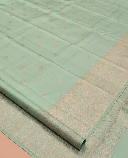 Green Kanchipuram Silk Saree, Delicately Woven with Zari Buttas All Over Its Body, Highlighted by a Zari Border of Floral and Paisley Designs, Grand Chevron Striped Pallu, and Paired with a Matching Blouse