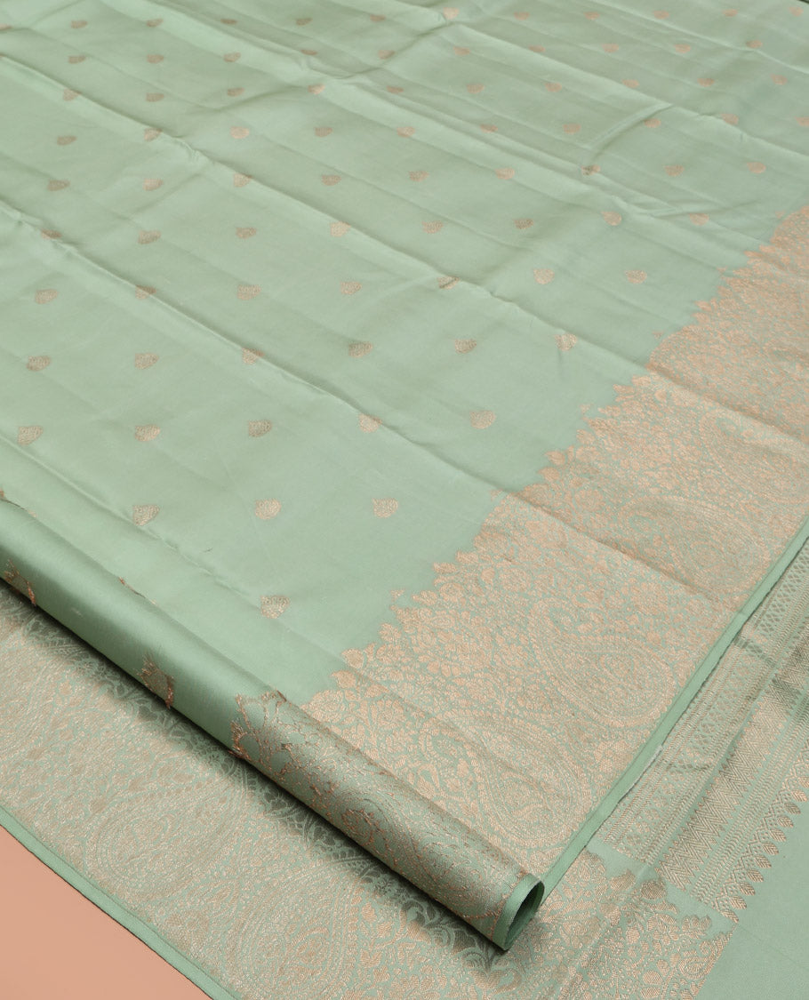 Green Kanchipuram Silk Saree, Delicately Woven with Zari Buttas All Over Its Body, Highlighted by a Zari Border of Floral and Paisley Designs, Grand Chevron Striped Pallu, and Paired with a Matching Blouse