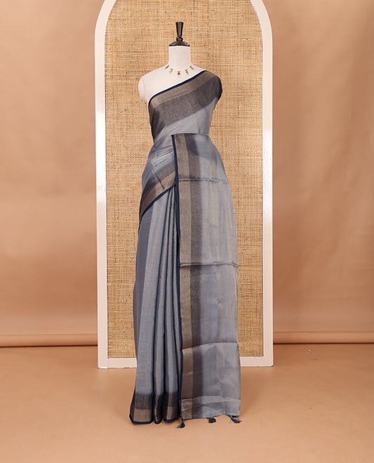 Grey plain tissue saree, contrast gold zari piping border & self pallu with tussels
