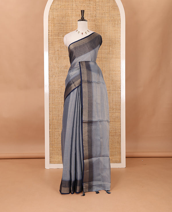Grey plain tissue saree, contrast gold zari piping border & self pallu with tussels
