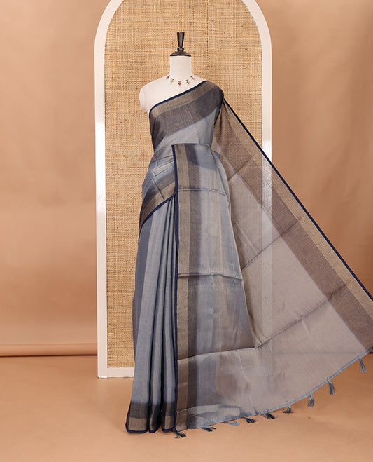 Grey plain tissue saree, contrast gold zari piping border & self pallu with tussels