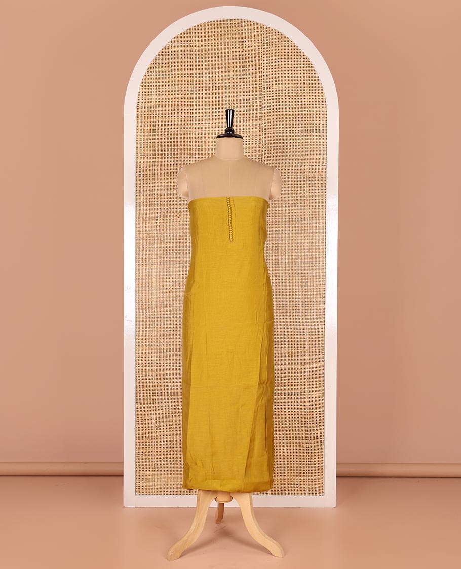 Mustard material chudidar set, plain with pom-pom tasseled mul chanderi top, a matching bottom, and organza dupatta of stripes