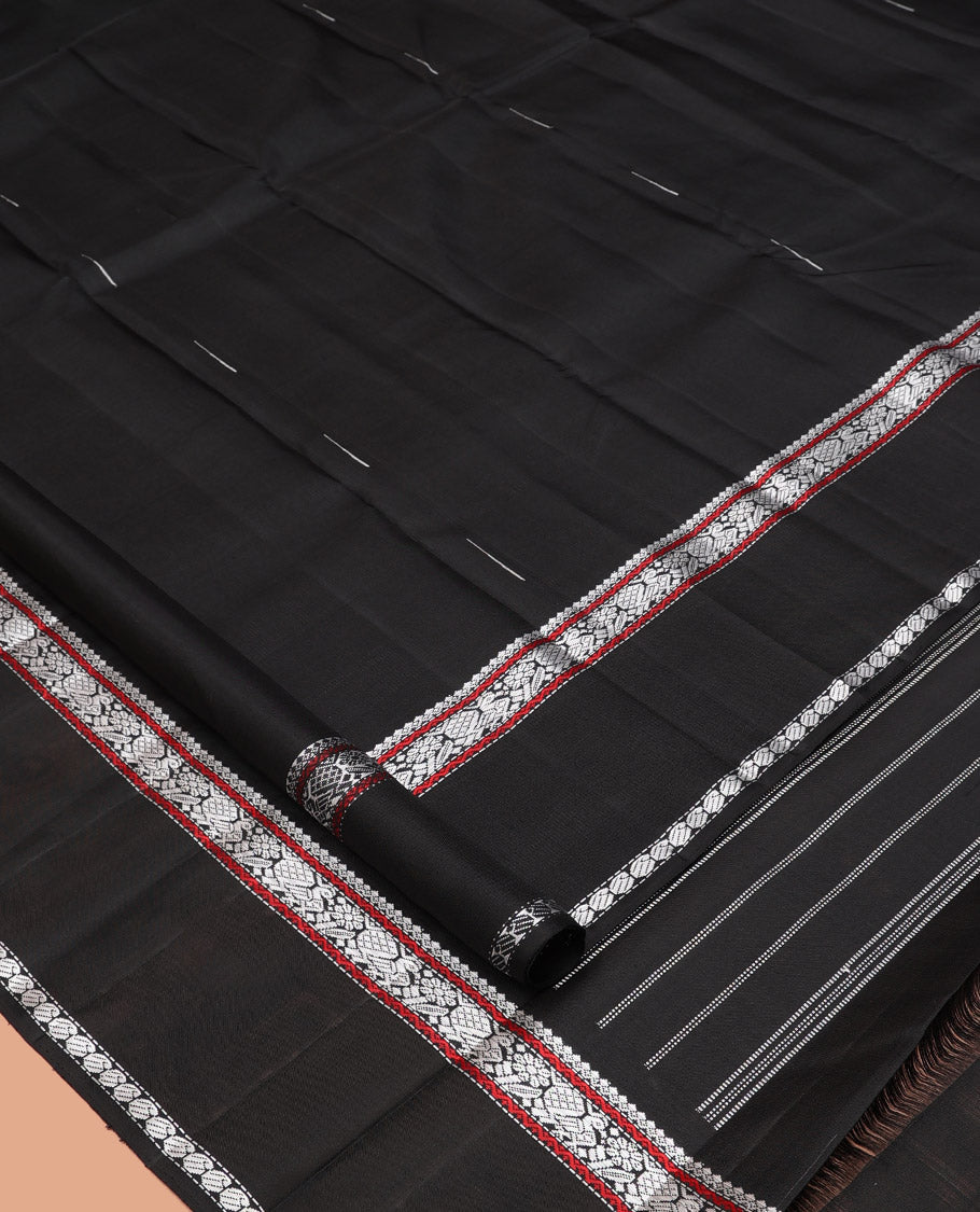 Black Kanchipuram Silk Saree, Delicately Woven with Buttas All Over Its Body, Highlighted by a Rettai Pettu Border of Thilakam Mokku, Neli, Mayil, and Manga Designs, Pallu Steeped with Stripes, and Paired with a Matching Blouse