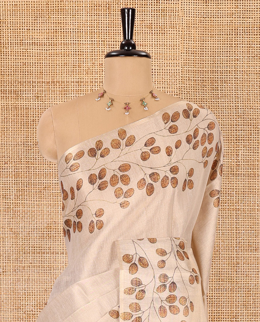 Cream plain body tissue saree with leaf vine printed border, printed pallu, and a contrast plain blouse
