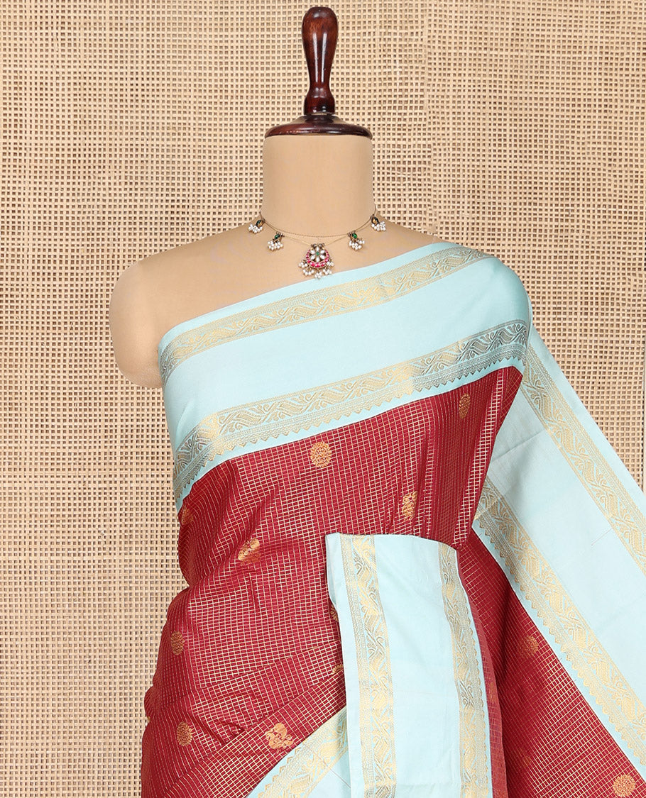 Red Budget Silk Saree, Elegantly Highlighted with Peacock-Chakram Zari Buttas and Checks All Over Its Body, Complemented by a Contrast Rettai Pettu Border of Traditional Designs, Scintillating Pallu, and Paired with a Contrast Blouse