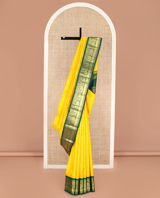 Yellow Kanchipuram Silk Saree, Decked Up with Zari Buttas, Complemented by Contrast One-Sided Korvai Border of Rekku, Banaras, Muthu, and Mayil Designs, Pallu Steeped with Round Mayil Designs, and Comes Without a Blouse