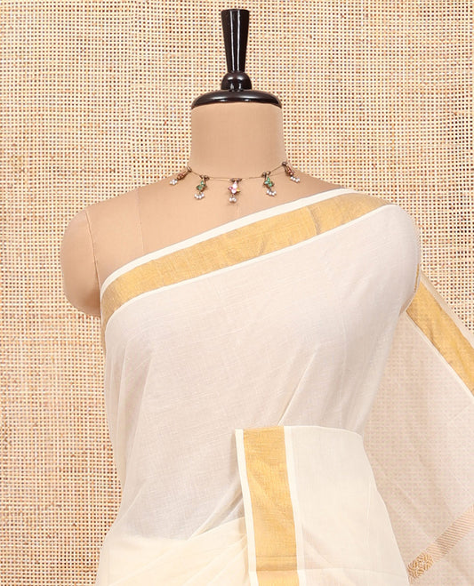 Cream Kerala Cotton Saree, Enthralled with Zari Stripes All Over Its Body, a Subtle Bavanji Border, Pallu of Intricate Designs, and Is Paired with a Matching Blouse