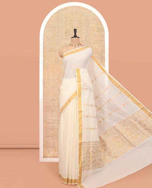 Cream Kerala Cotton Saree, Enthralled with Zari Stripes All Over Its Body, a Subtle Bavanji Border, Pallu of Intricate Designs, and Is Paired with a Matching Blouse