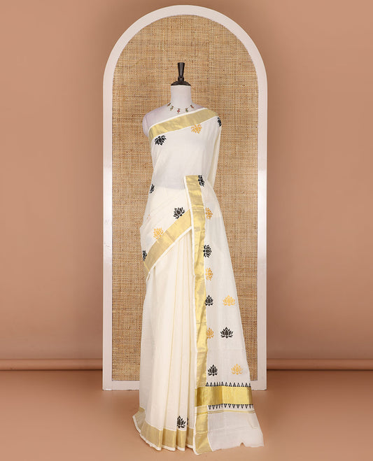 Half-white lotus motifs printed Kerala cotton saree, gold zari border, lotus motifs printed pallu, and matching blouse