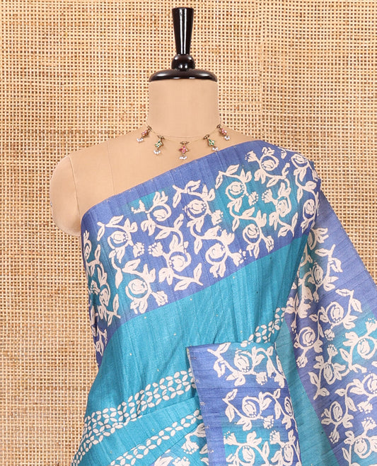 Blue sparkling dots and batik printed semi-tussar saree, contrast batik printed floral vine border, printed pallu, and a contrast printed blouse