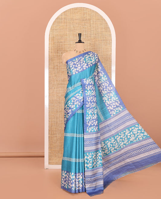 Blue sparkling dots and batik printed semi-tussar saree, contrast batik printed floral vine border, printed pallu, and a contrast printed blouse