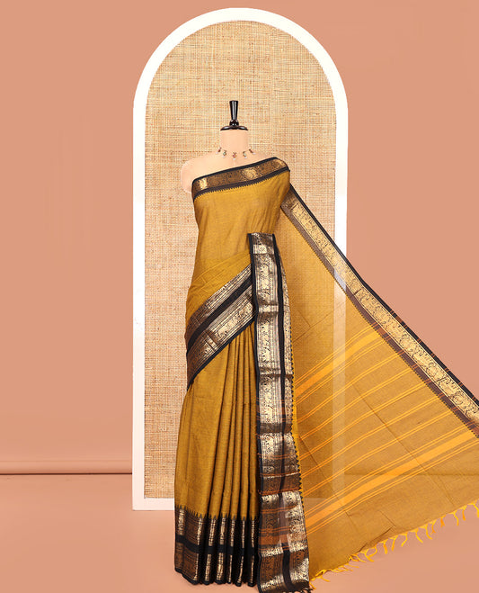 Mustard Plain Chettinad Cotton Saree, Complemented by a Contrast Rettai Pettu Temple Antique Gold Zari Border of Coin, Elephant, and Peacock Designs, Subtly Striped Pallu, and Paired with a Matching Blouse