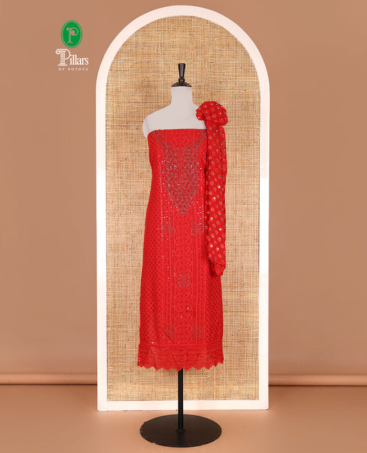 Red material churidar set, stone work with Schiffli style embroidered georgette top, American Crape bottom, and polka dotted printed mirror work dupatta