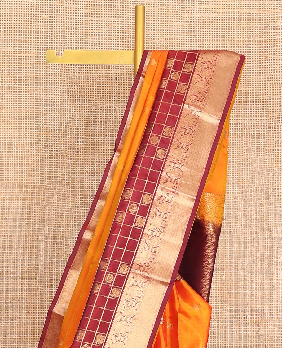 Orange Vasundhara Lite-Silk Mix Saree, Enthralled with Zari Buttas All Over Its Body, Complemented by a Contrast Annam Chakram Enclosed Checked Border of Kamalam, Manga, and Yaanai Designs, Grand Pallu of Jaal Designs, and Paired with a Contrast Blouse