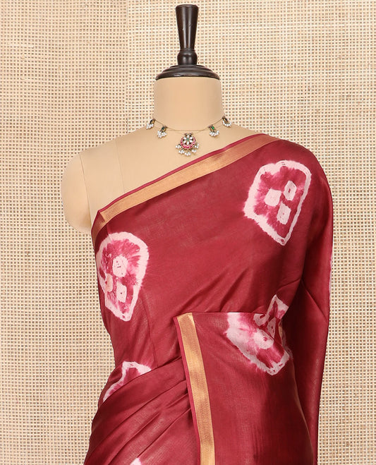 Maroon Banana Pith Saree Elevated with Bright Shibori Print, Subtly Woven Zari Bavanji Border, Pallu Featuring Shibori Print, and Paired with a Matching Shibori Printed Blouse