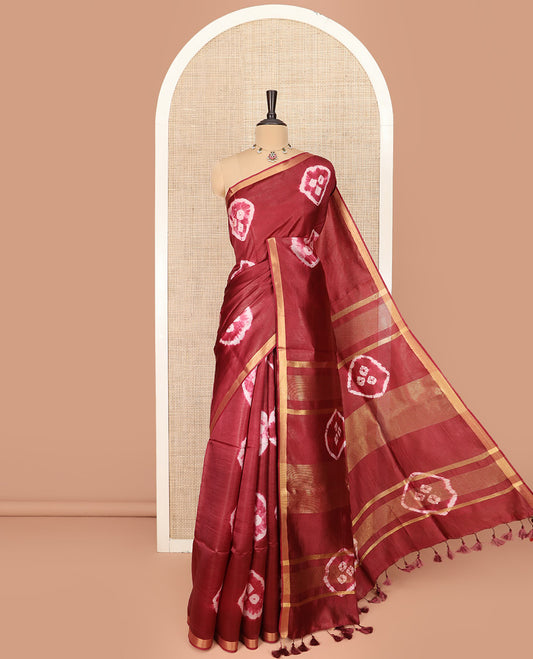 Maroon Banana Pith Saree Elevated with Bright Shibori Print, Subtly Woven Zari Bavanji Border, Pallu Featuring Shibori Print, and Paired with a Matching Shibori Printed Blouse