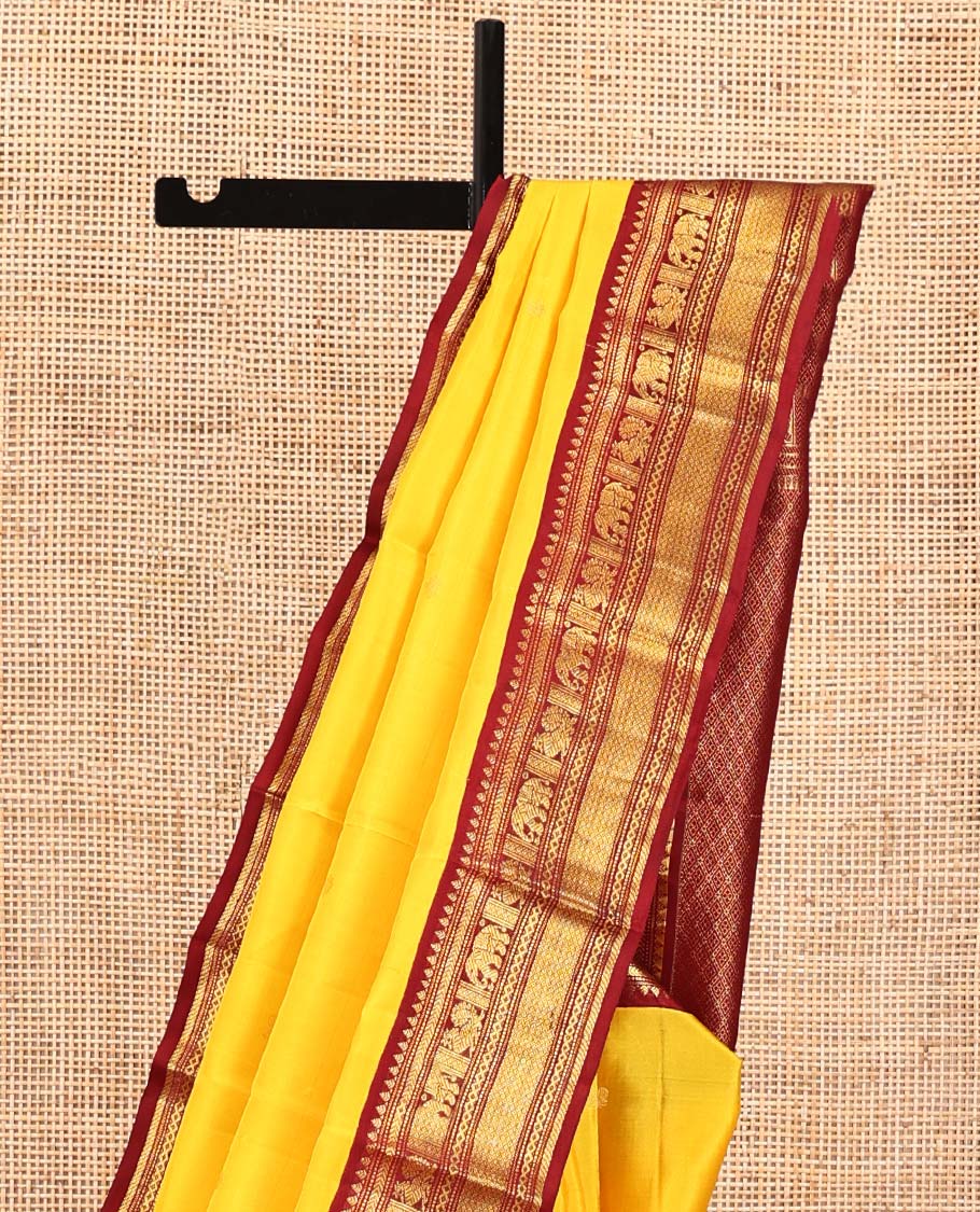 Yellow Vasundhara Silk Saree, Subtly Sparkled with Buttas All Over Its Body, Complemented by a Contrast Border of Thilakam, Neli, Kathir, Mayil, Yaanai, and Mayil Kann Designs, Grand Jaal Pallu, and Paired with a Contrast Blouse