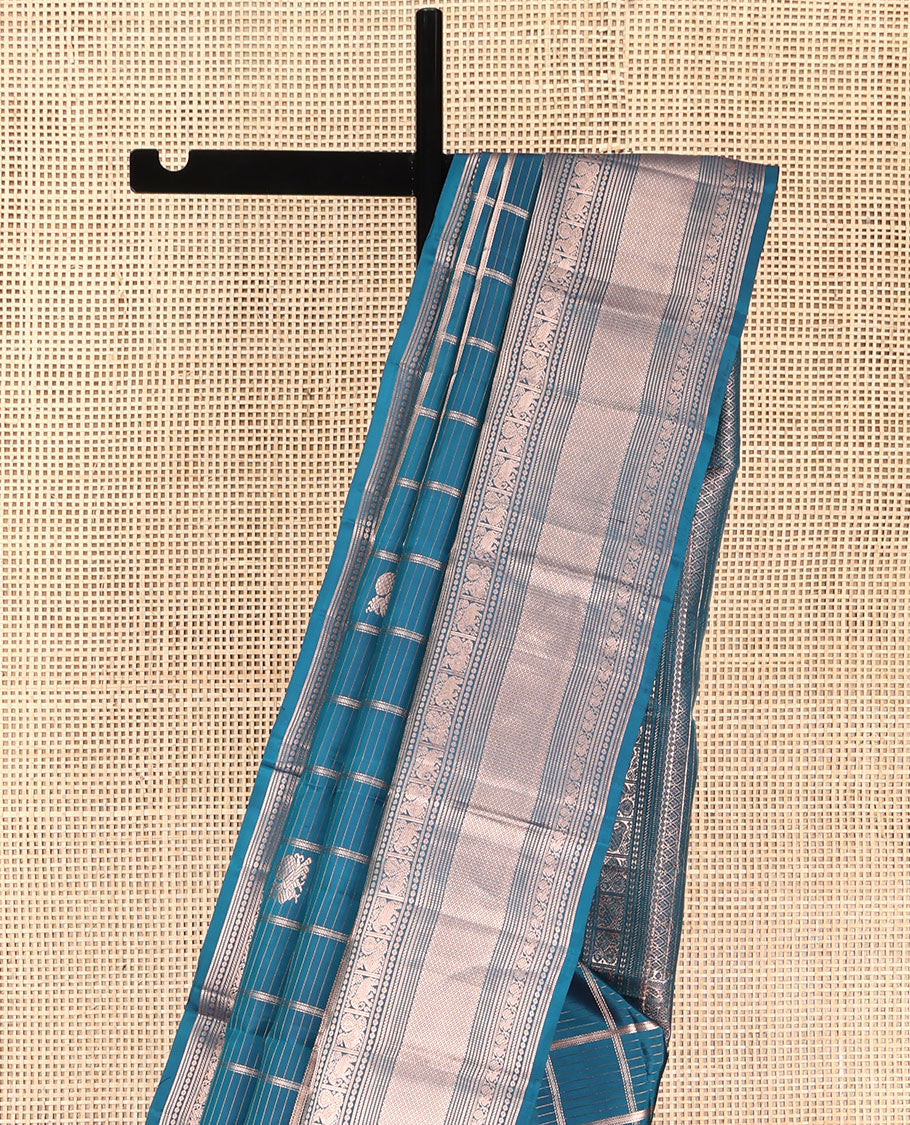 Blue Vasundhara Silk Saree, Enriched with Zari Butta Enclosed Checked Design All Over Its Body, Highlighted by Zari Border of Thilakam Mokku, Muthu, Mayil, Yaanai, and Mayil Kann Designs, Grand Jaal Pallu, and Paired with a Matching Blouse