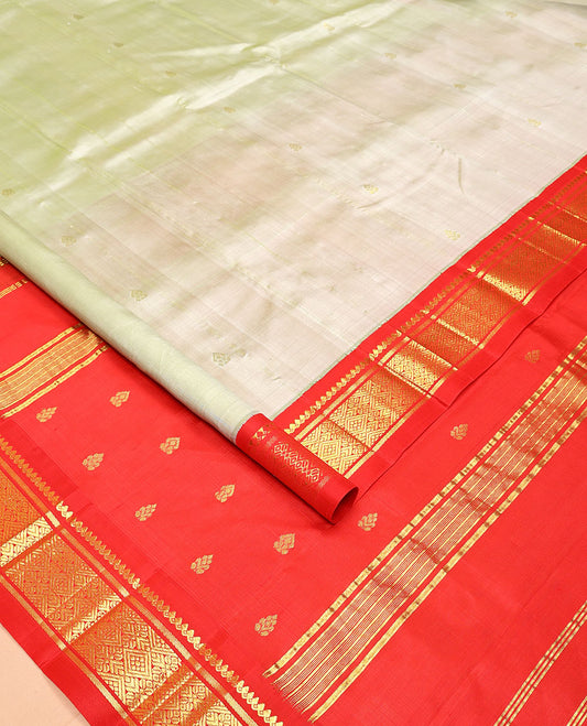 Pale Green Kanchipuram Silk Saree, Mesmerized with Zari Buttas All Over Its Body, Complemented by a Contrast One-Sided Korvai Border of Thilakam Mokku, Banaras, and Jaal Designs, Pallu of Zari Designs, and Comes Without a Blouse