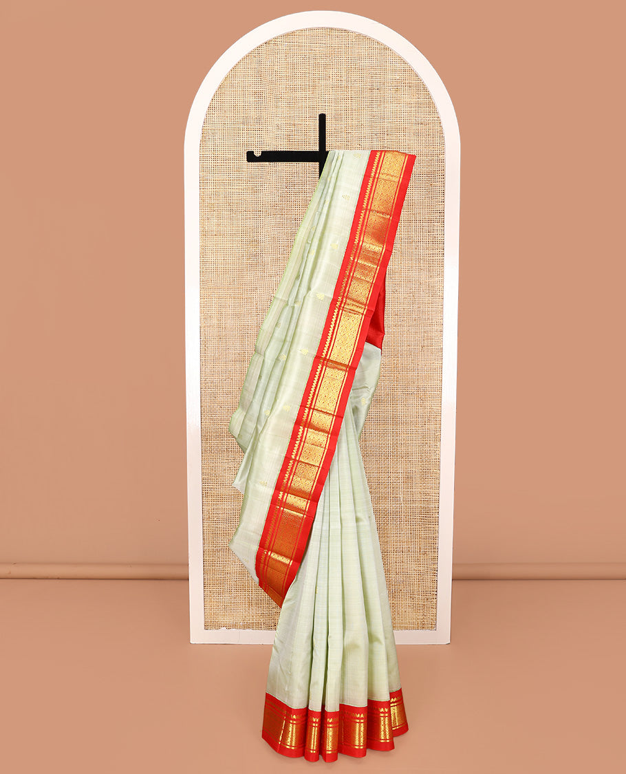 Pale Green Kanchipuram Silk Saree, Mesmerized with Zari Buttas All Over Its Body, Complemented by a Contrast One-Sided Korvai Border of Thilakam Mokku, Banaras, and Jaal Designs, Pallu of Zari Designs, and Comes Without a Blouse