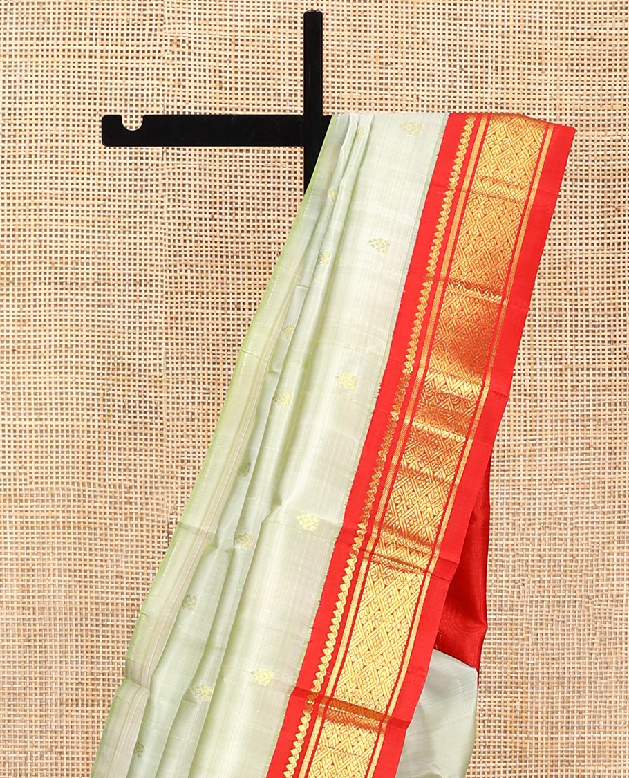 Pale Green Kanchipuram Silk Saree, Mesmerized with Zari Buttas All Over Its Body, Complemented by a Contrast One-Sided Korvai Border of Thilakam Mokku, Banaras, and Jaal Designs, Pallu of Zari Designs, and Comes Without a Blouse