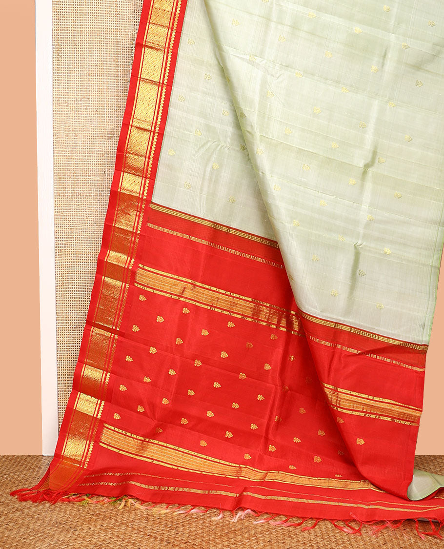 Pale Green Kanchipuram Silk Saree, Mesmerized with Zari Buttas All Over Its Body, Complemented by a Contrast One-Sided Korvai Border of Thilakam Mokku, Banaras, and Jaal Designs, Pallu of Zari Designs, and Comes Without a Blouse