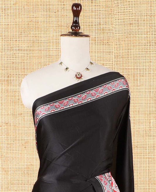 Black half-&-half style modal satin saree features floral & geometric design Ajrakh printed contrast border & pallu