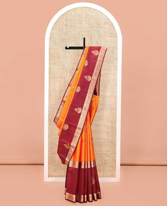 Orange Vasundhara Lite Silk Mix Saree, Subtly Sparkled with Zari Buttas All Over Its Body, Complemented by a Contrast Border of Thilakam, Kamalam, and Round Mayil Designs, Intricately Designed Pallu, and Paired with a Contrast Blouse