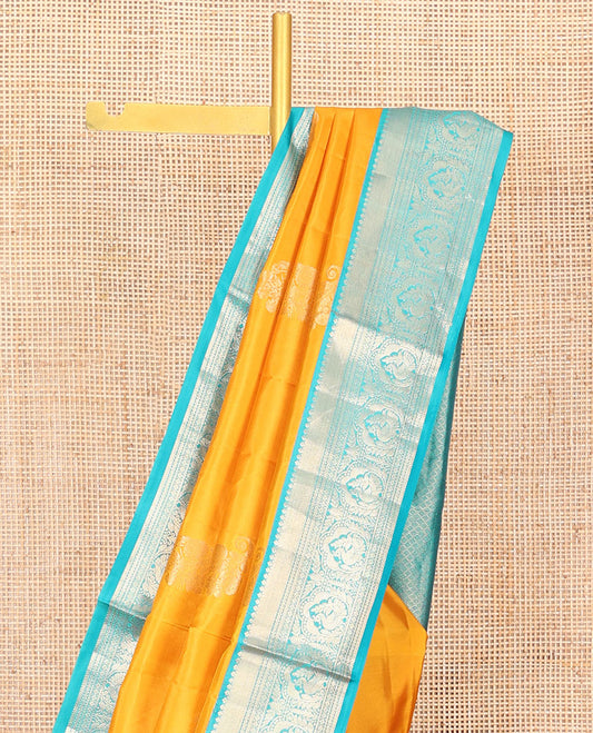 Yellow Vasundhara Silk Saree Ornamented with Zari Buttas All Over Its Body, Complemented by a Contrast Border of Neli, Kathir, Rudraksham, and Mayil Designs, Pallu Featuring Jaal Designs, and Paired with a Contrast Blouse