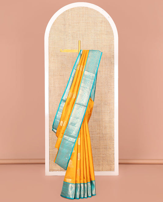 Yellow Vasundhara Silk Saree Ornamented with Zari Buttas All Over Its Body, Complemented by a Contrast Border of Neli, Kathir, Rudraksham, and Mayil Designs, Pallu Featuring Jaal Designs, and Paired with a Contrast Blouse