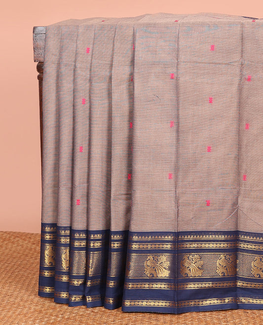 Grey Chettinad Cotton Saree, Sparsely Sparkled with Thread Buttas on Its Body, Complemented by a Contrast Varisai Pettu Traditional Border of Peacocks, Subtly Striped Pallu, and Paired with a Matching Blouse