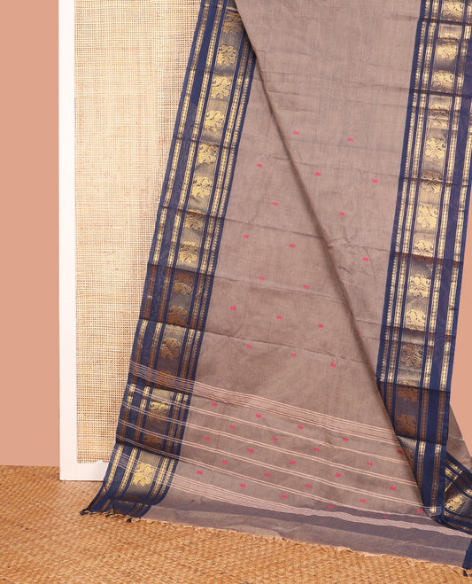 Grey Chettinad Cotton Saree, Sparsely Sparkled with Thread Buttas on Its Body, Complemented by a Contrast Varisai Pettu Traditional Border of Peacocks, Subtly Striped Pallu, and Paired with a Matching Blouse