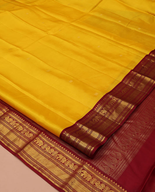 Yellow Vasundhara Silk Saree, Subtly Sparkled with Buttas All Over Its Body, Complemented by a Contrast Border of Thilakam, Neli, Kathir, Mayil, Yaanai, and Mayil Kann Designs, Grand Jaal Pallu, and Paired with a Contrast Blouse