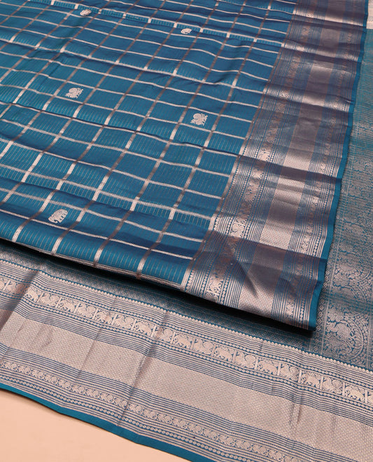 Blue Vasundhara Silk Saree, Enriched with Zari Butta Enclosed Checked Design All Over Its Body, Highlighted by Zari Border of Thilakam Mokku, Muthu, Mayil, Yaanai, and Mayil Kann Designs, Grand Jaal Pallu, and Paired with a Matching Blouse