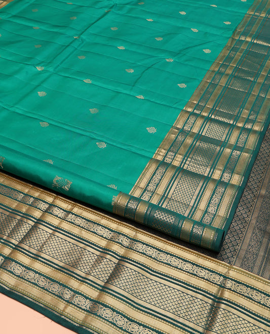 Green Kanchipuram Silk Saree, Detailed with Buttas on Its Body, Complemented by a Contrast Border of Vanki, Kodi Visiry, Neli, Banaras, and Jaal Designs, Grandly Jaal Woven Pallu, and Paired with a Contrast Blouse