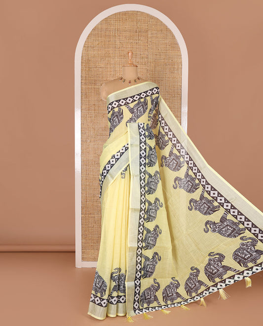 Yellow plain linen cotton saree, silver zari border of elephant motifs print, elephant motifs pallu, and a contrast elephant motifs printed blouse
