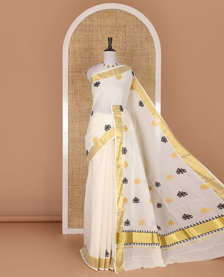 Half-white lotus motifs printed Kerala cotton saree, gold zari border, lotus motifs printed pallu, and matching blouse