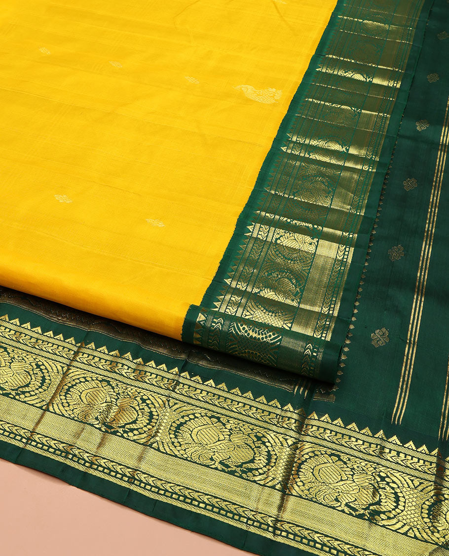Yellow Kanchipuram Silk Saree, Decked Up with Zari Buttas, Complemented by Contrast One-Sided Korvai Border of Rekku, Banaras, Muthu, and Mayil Designs, Pallu Steeped with Round Mayil Designs, and Comes Without a Blouse