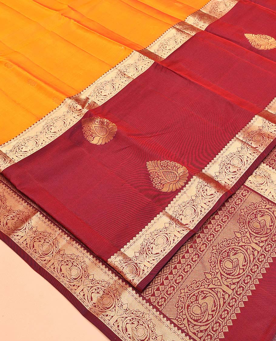 Orange Vasundhara Lite Silk Mix Saree, Subtly Sparkled with Zari Buttas All Over Its Body, Complemented by a Contrast Border of Thilakam, Kamalam, and Round Mayil Designs, Intricately Designed Pallu, and Paired with a Contrast Blouse