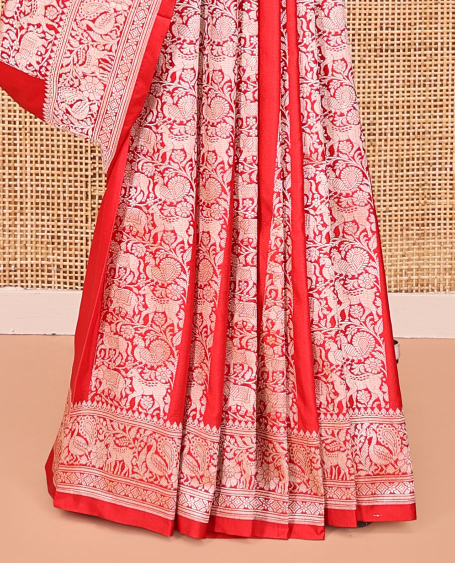 Red Mushuru Silk Saree, Gracefully Embellished with Vertically Woven Flora-Fauna Zari Designs On Its Body, Highlighted by Zari Border of Peacock and Deer Motifs, Grand Pallu, and Paired with a Plain Blouse