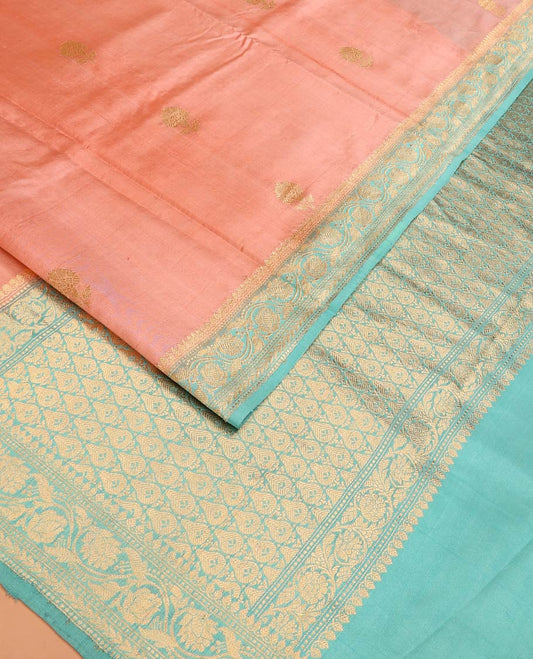 Peach Raw Mango Silk Saree Bedecked with Buttas, Features a Contrast floral creeper design Border, adorned with intricately designed Pallu, and comes with a Contrast Blouse