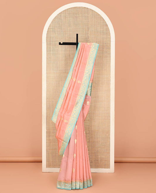 Peach Raw Mango Silk Saree Bedecked with Buttas, Features a Contrast floral creeper design Border, adorned with intricately designed Pallu, and comes with a Contrast Blouse